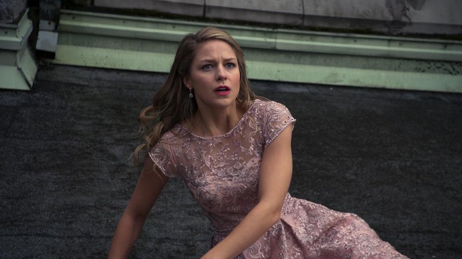 Kara lands on the roof after being thrown out of the building be her evil alternate.