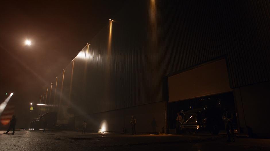 The Resistance members stand outside the warehouse at night.