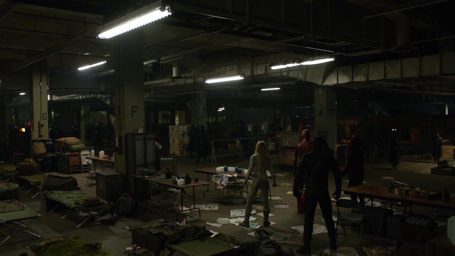 Sara, Barry, Oliver, and Alex stand in the building as Earth-X soldiers surround them.