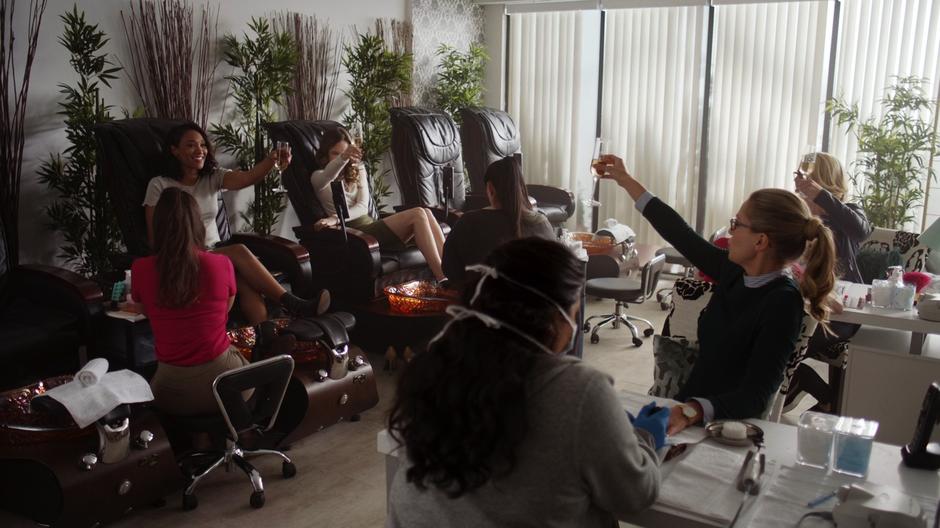 The girls raise their champagne glasses in a toast.