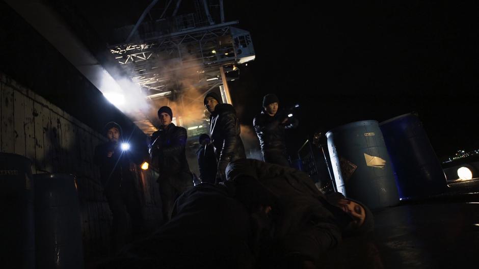 The gang members look down as one of the guys crashes to the ground after being attacked by Reign.