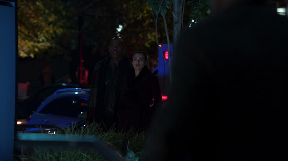 James and Lena look over at Kara where she lies unconscious.