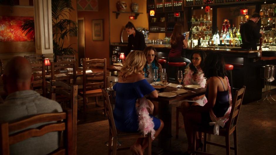 Felicity, Caitlin, Cecile, and Iris sit at the table for the bachelorette party.