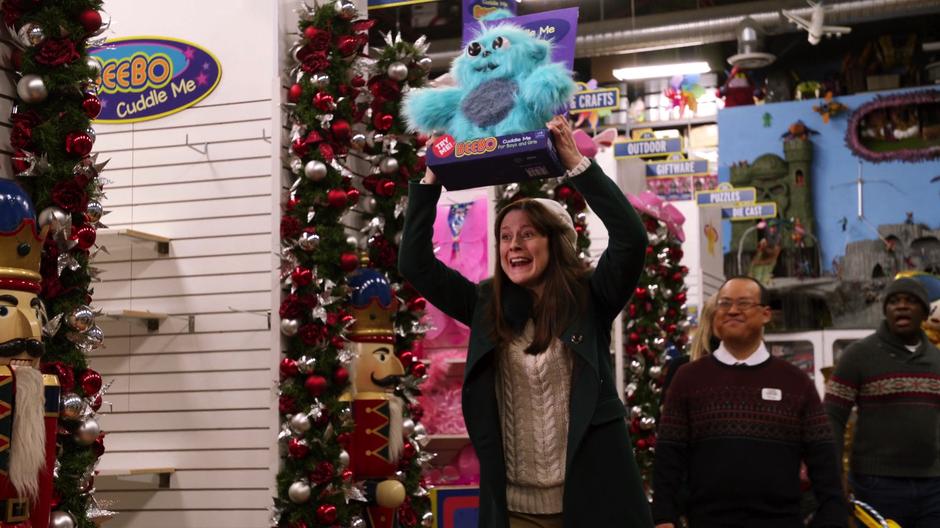 A woman excitedly holds up the last Beebo.