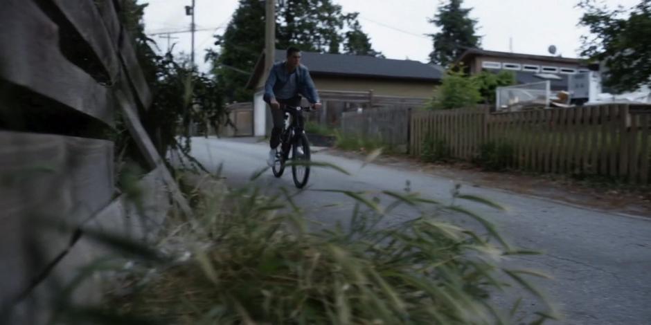 Trevor bikes down the alley.