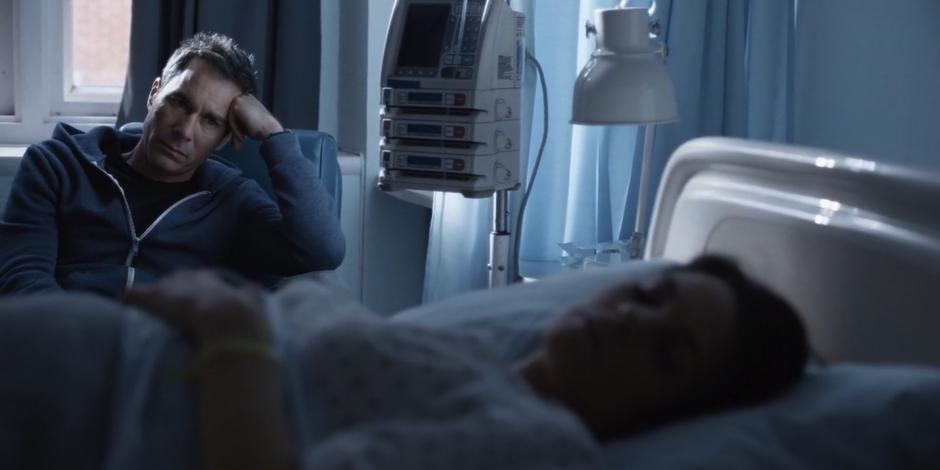 Grant watches Kat as she sleeps in the hospital bed.