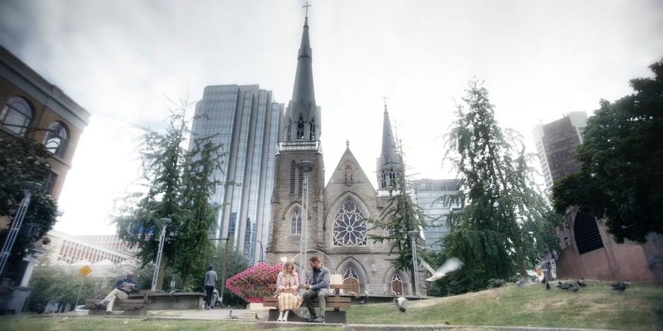 David sits with Marcy on the bench in the park as she reads from her book.