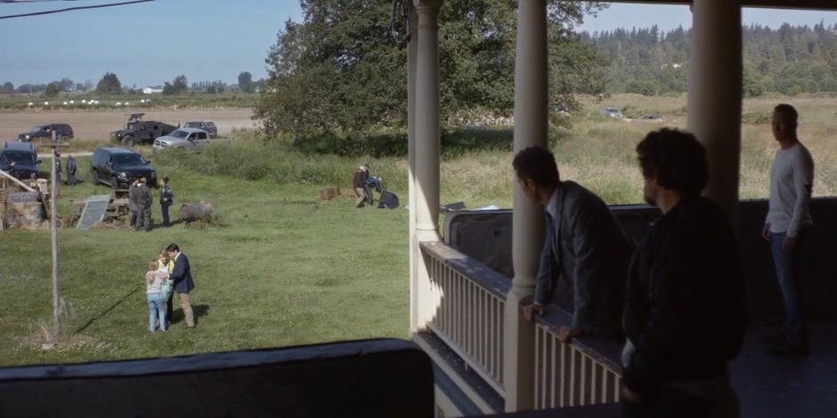 Grant, Rick, and Luca watch from the porch as Anna Hamilton reunites with her parents.