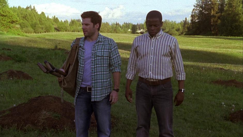 Shawn and Gus return to the field with shovels looking for the correct place to dig.