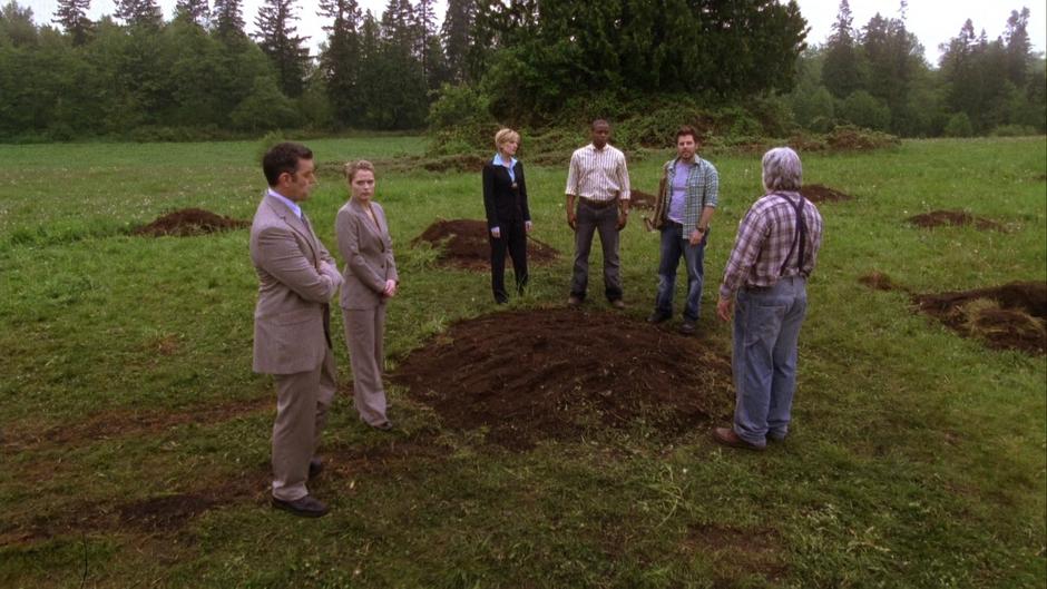 Lassiter, Juliet, Vick, Gus, and Walker stand around one of the holes while Shawn explains the case.