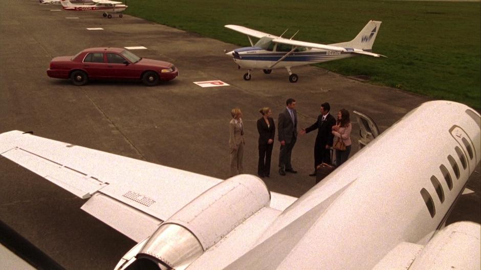 Ewing and Leikin say goodbye to Vick, Juliet, and Lassiter beside their private plane.