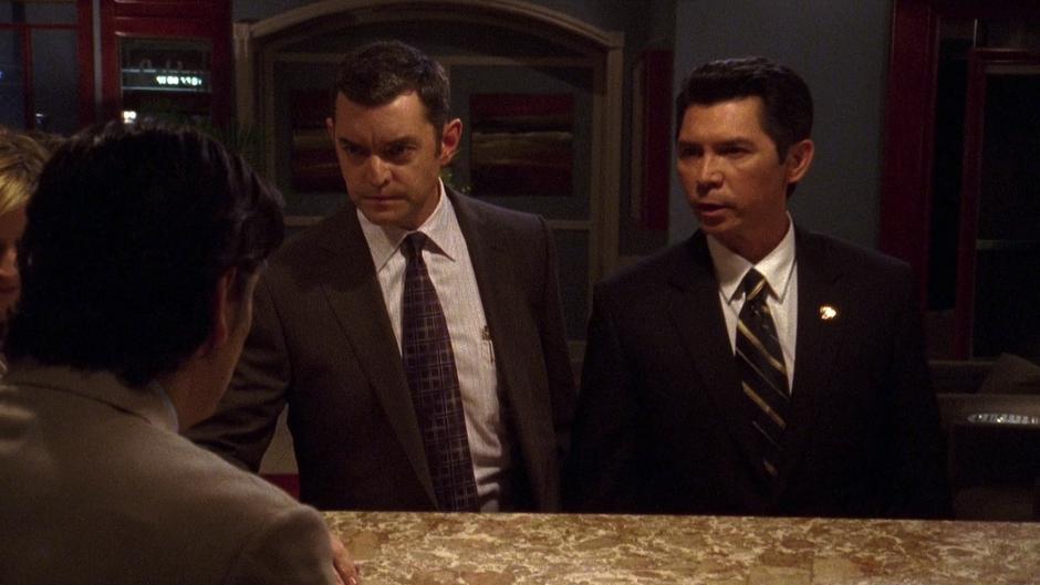 Lassiter and Special Agent Ewing both try to ask the hotel clerk a question.