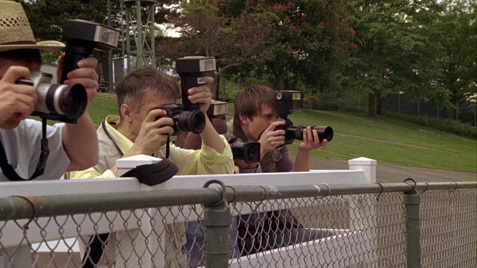 The photographer watches the race and prepares to fire.