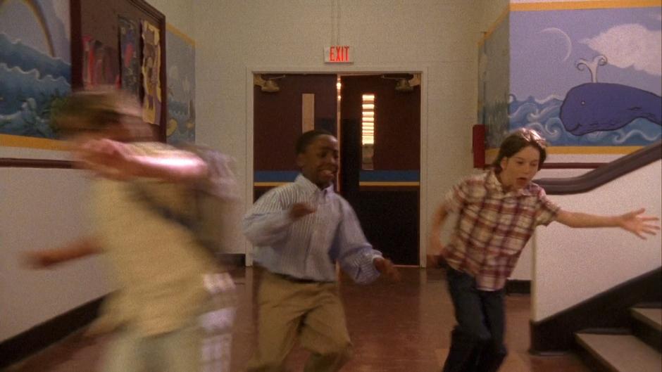 Gus and Shawn turn the corner in the hallway.