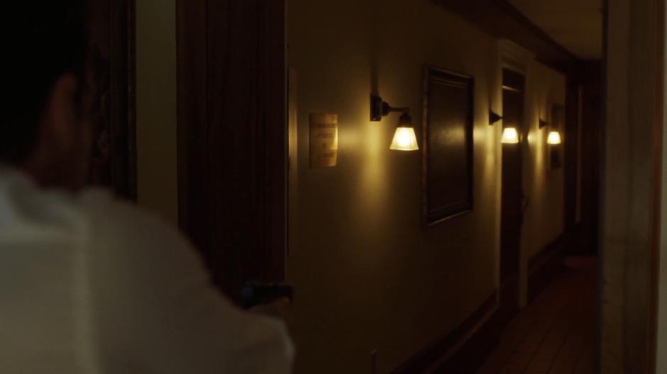 Mulder looks down an empty side hallway.