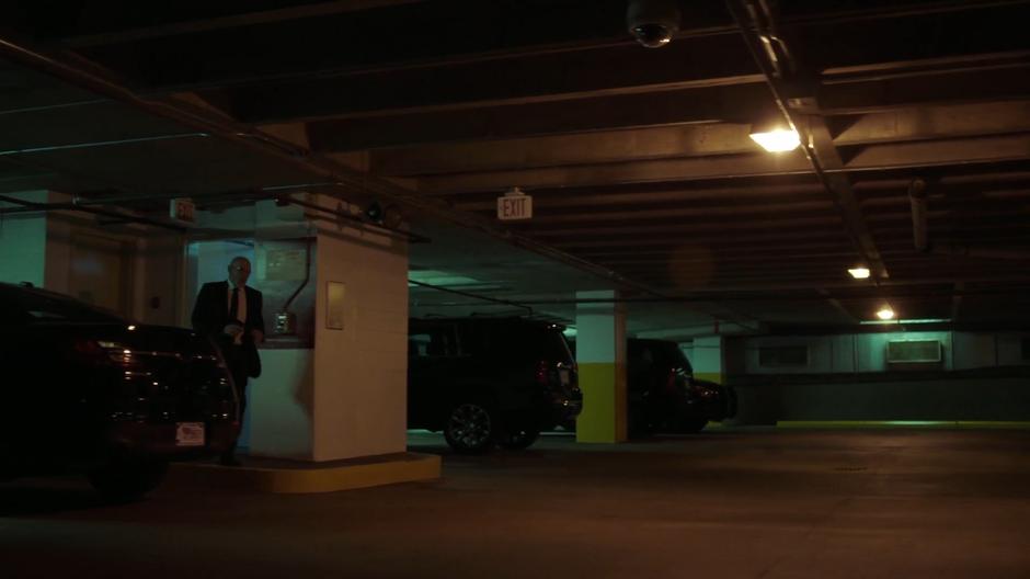 Skinner walks through the parking garage from the elevator.