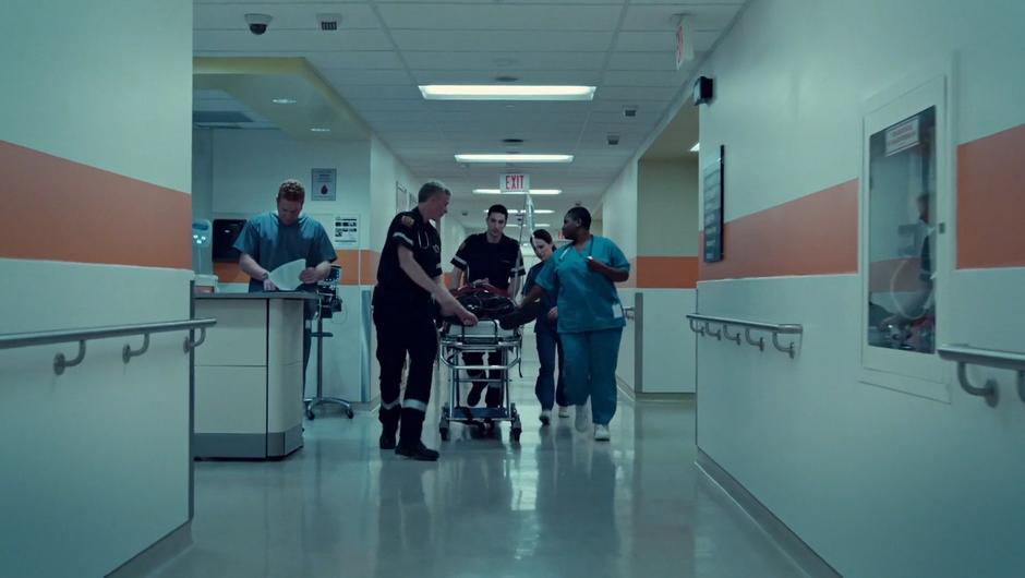 Mary talks to the paramedics with Connie while wheeling their latest patient through the hall.