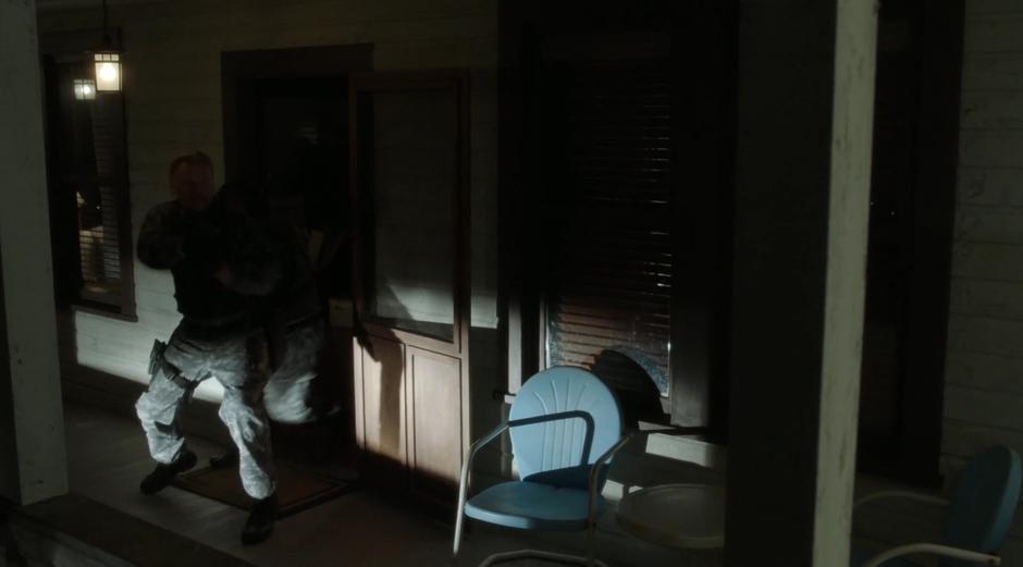 The mercenaries exit the house chasing after Mulder and Scully.