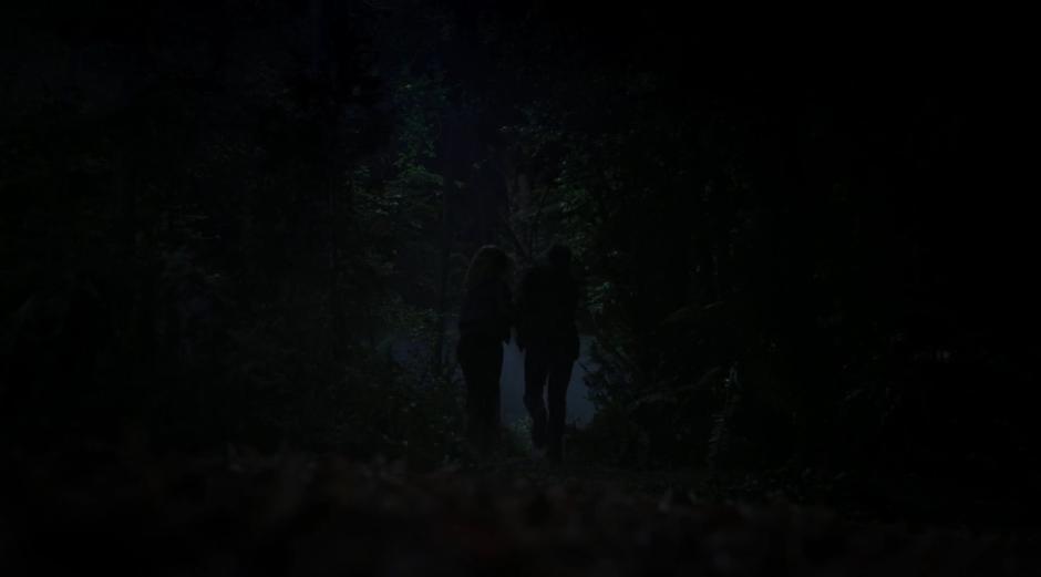 Scully and Mulder run off through the woods.