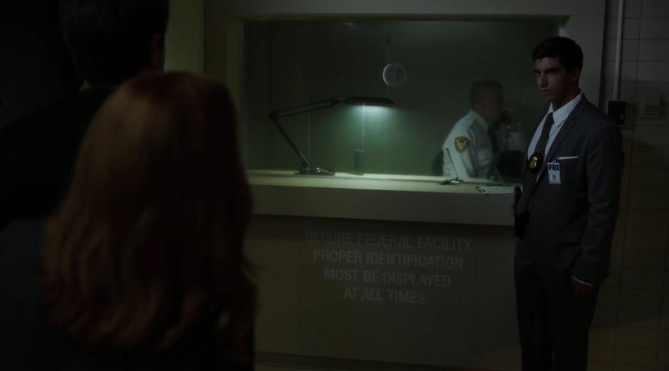 A FBI agent greets Scully and her prisoner.