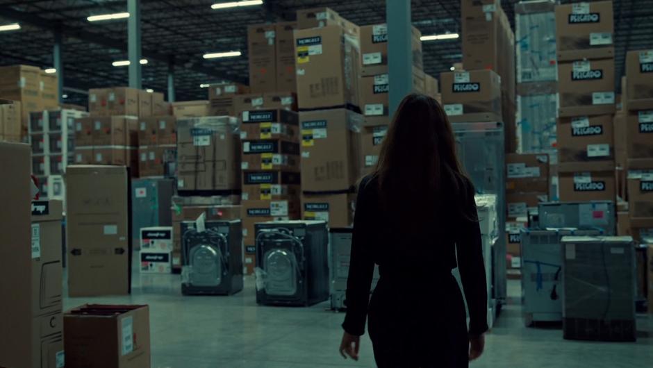 Mary walks into the warehouse and looks around.
