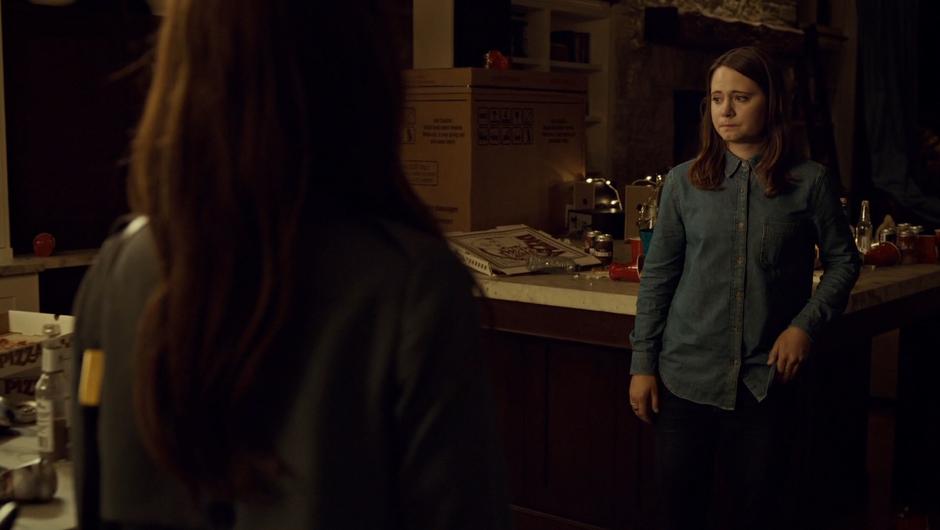 Jess stands nervously in the trashed kitchen as Mary walks in.