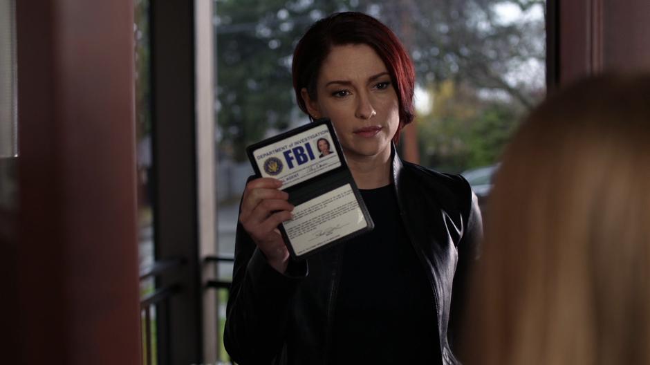 Alex shows Erika Morrison her FBI badge.