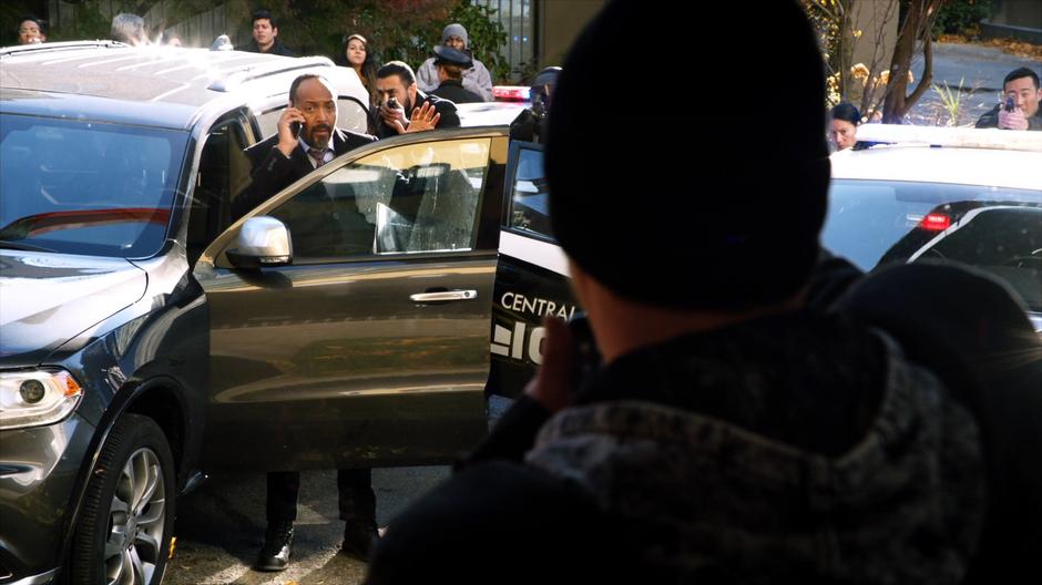 Joe tries to negotiate with the robber from the line of police cars outside the store.