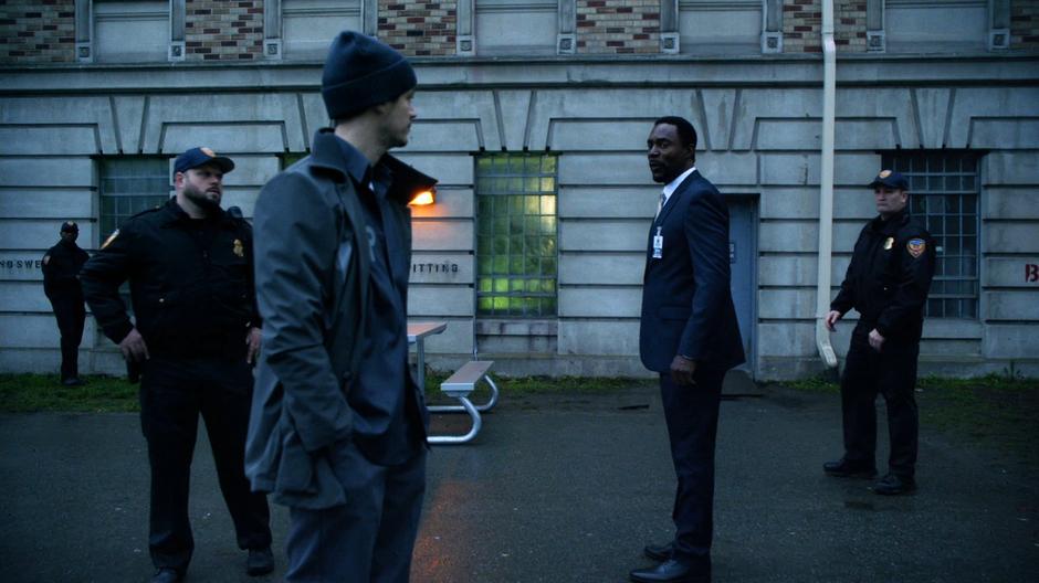 Barry talks with the warden Wolfe in the yard while a couple of guards keep an eye on him.