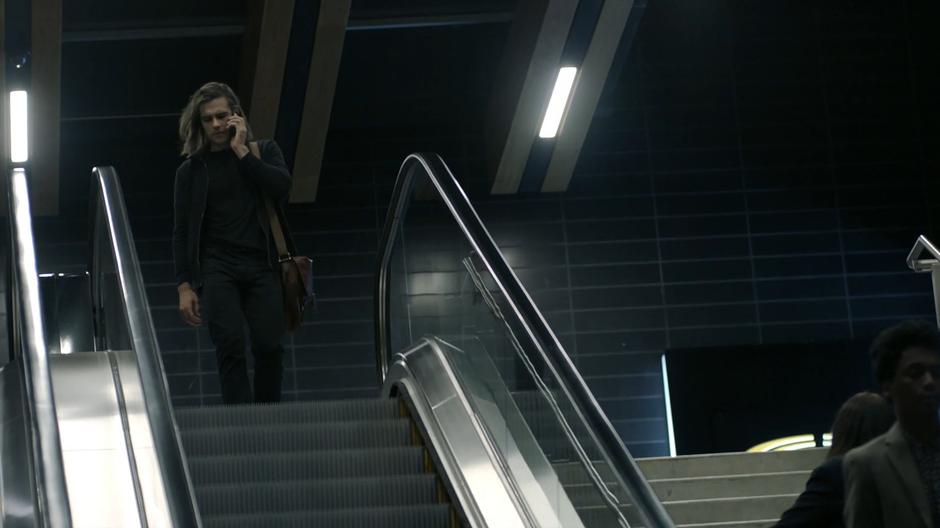 Quintin talks to Julia on the phone while he walks onto the top of the escalator.