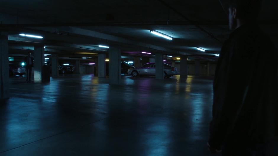 Mulder sees Reggie standing beside a pillar in the parking garage.