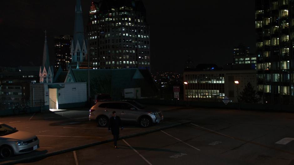 Edge walks across the parking lot from the stairs to his car.