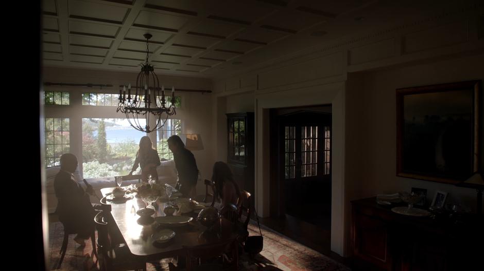 Dean Fogg, Irene McAllistair, Quentin, and Julia sit down at the table.