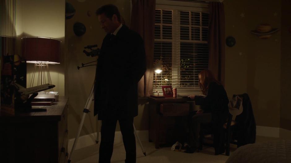 Mulder and Scully search through Jackson Van De Kamp's bedroom.