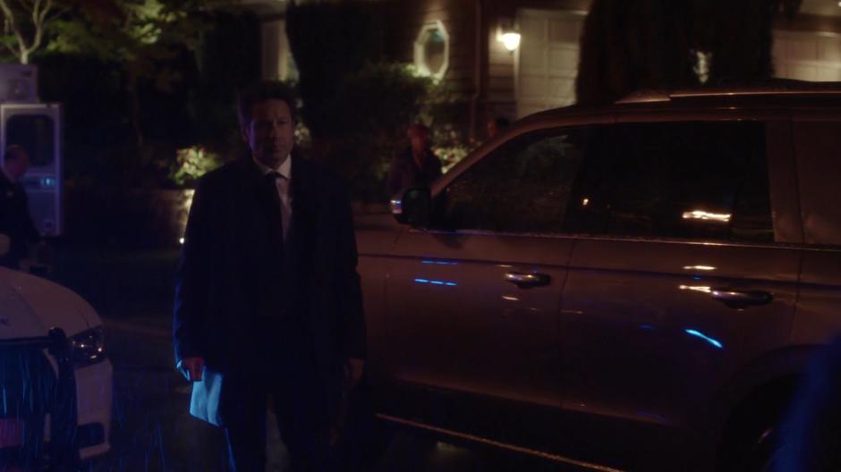 Mulder walks over to the two agents in the driveway.