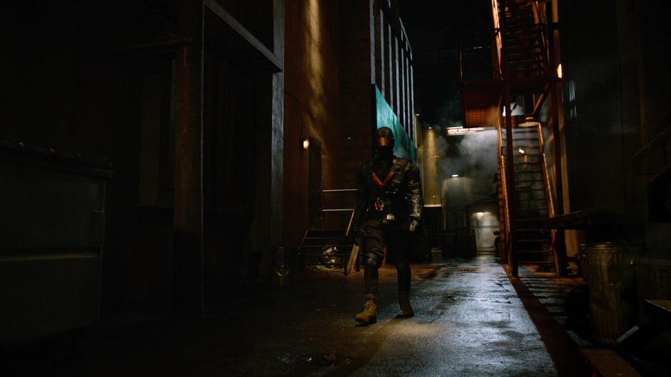 Vincent walks down the alley in his Vigilante getup.
