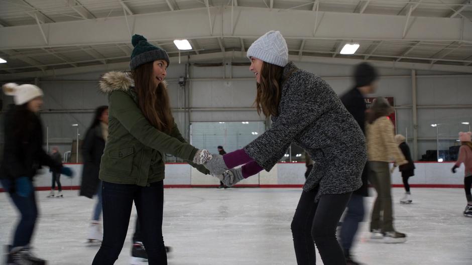 Ruby and Sam hold hands in the middle of the rink while preparing to race.