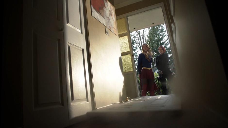 Kara kicks in the front door of the house with Alex by her side.