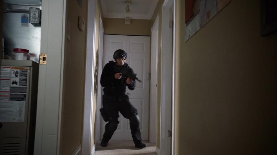 A DEO agent searches through the interior of the house.