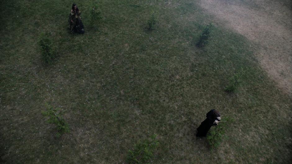 Margo walks through the ring of trees to where Eliza is tending to the trees.