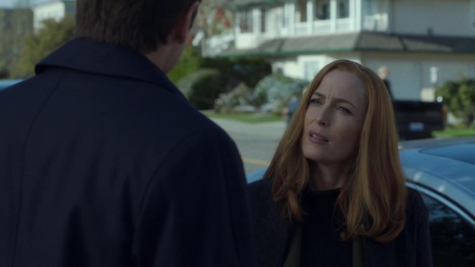 Scully stops Mulder briefly before they get into their car.