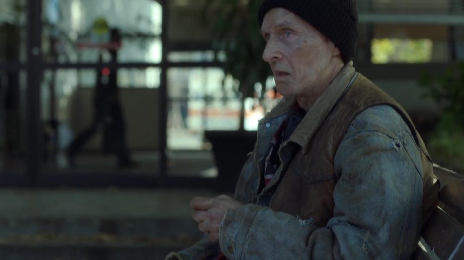 The homeless man looks up from the bench as Mulder approaches him.