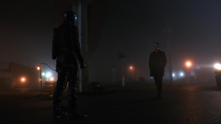 Cayden James walks over to where Diggle and Oliver have stopped in front of his car.