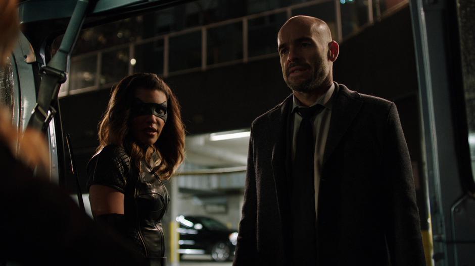 Dinah and Lance look into the van where Black Siren is tied up.