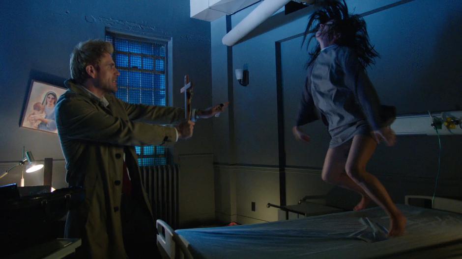 Nora Darhk is lifted into the air by the demon while Constantine attempts to exorcise her.