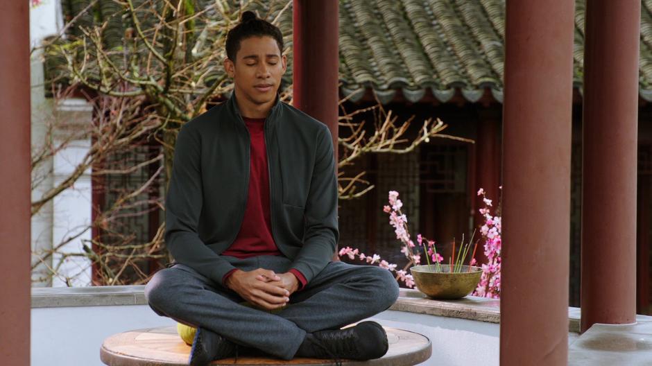 Wally West meditates in a small covered area.