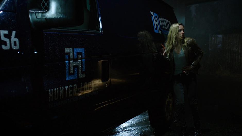 Black Siren stumbles against the van while holding her injury.