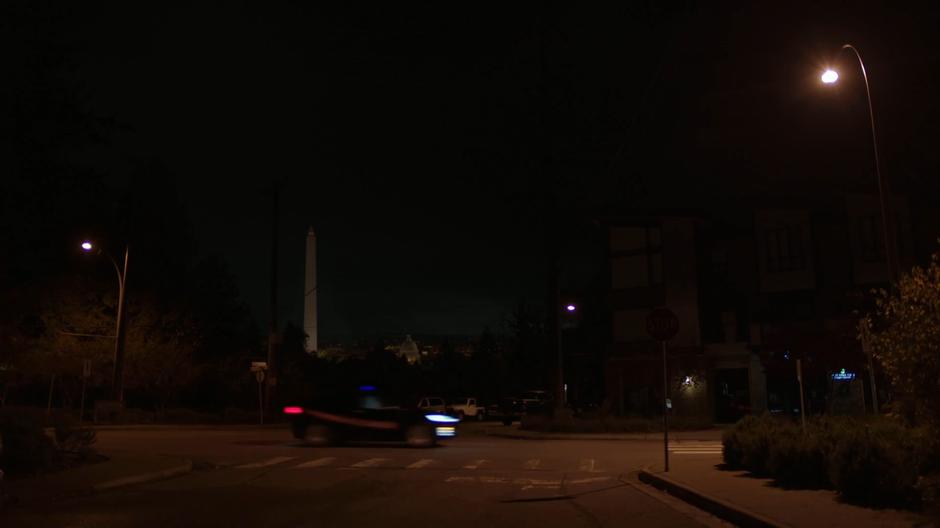 The driverless car passes through an intersection with the Washington Monument visible in the background.