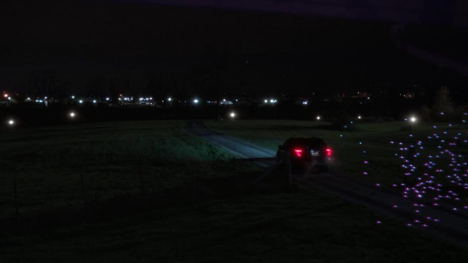 Mulder drives away from his house while being pursued by a swarm of tiny drones.