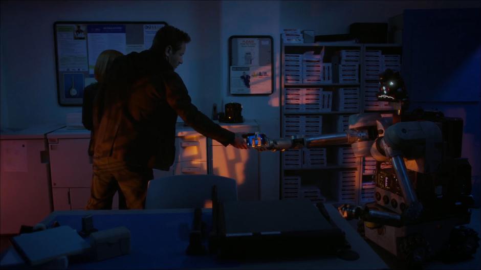 Mulder takes his phone from the terrifying robot.